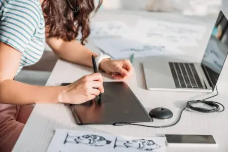 Projektant stron internetowych pracuje przy biurku z laptopem